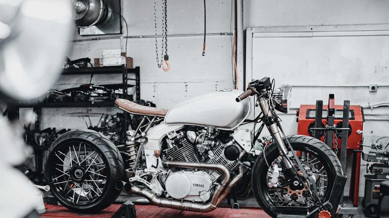 Warsztat motocyklowy — motocykl typu cafe racer na podnośniku podczas serwisu